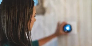a woman using adjusting a thermostat